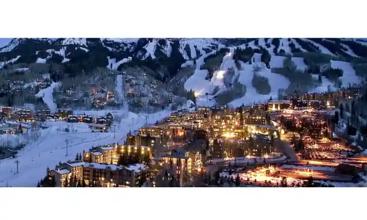 The town of aspen is shown in the picture at night time. The lights and snow at the time of dawn create magic.