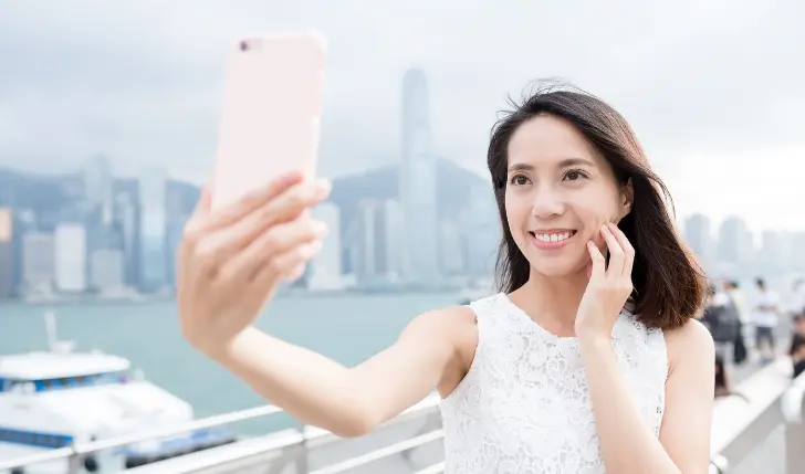 Women taking selfies on a cruise while elaborating that AT&T cruise plan is worth it as it is cost-effective.