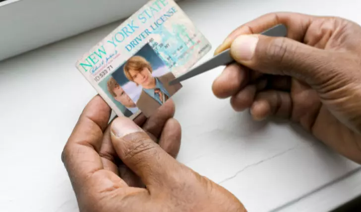 A person is forging an ID which is illegal