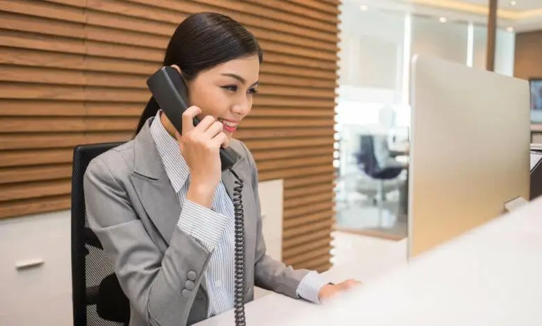 Picture shows a hotel receptionist on the telephone acting as front desk manager to solve queries of clients