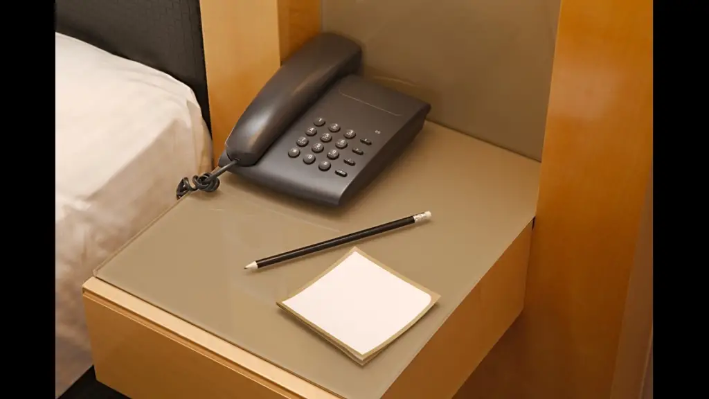 The picture shows a bedside telephone in a hotel room to call the front desk or for any related service requirement