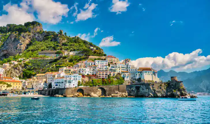 The picture shows the town on Amalfi from the beachside to the mountainous city during the comparison article with Ravello