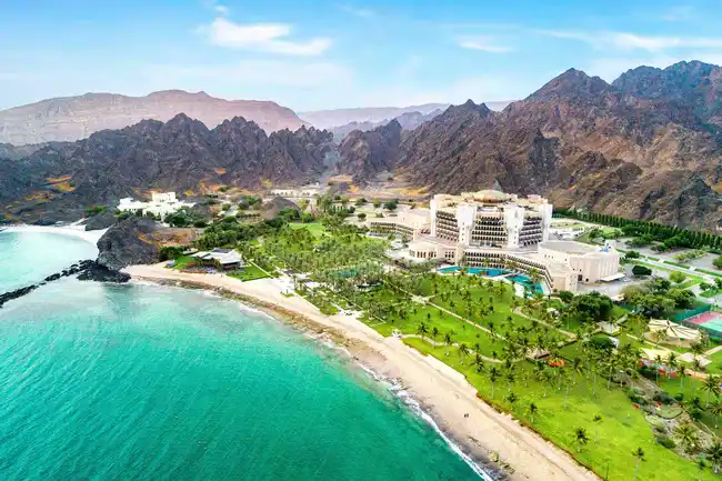 Al-Bustan Palace Hotel by Ritz Carlton is shown in the picture which is situated between Oman and Hajar mountains while comparing the hotel chain with St. Regis hotels