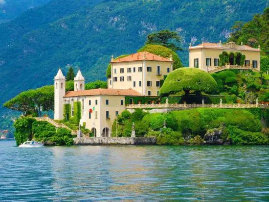 The picture shows an ancient villa style hotel along the Lake Como