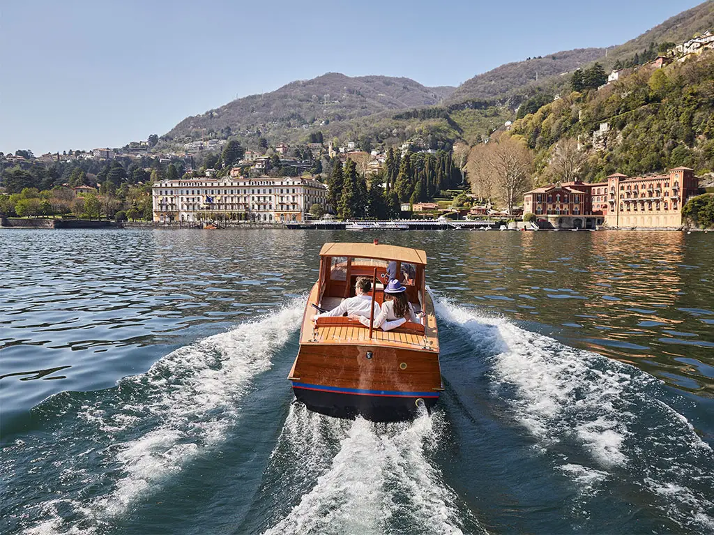 The picture shows a couple taking a private boat ride in Lake Como