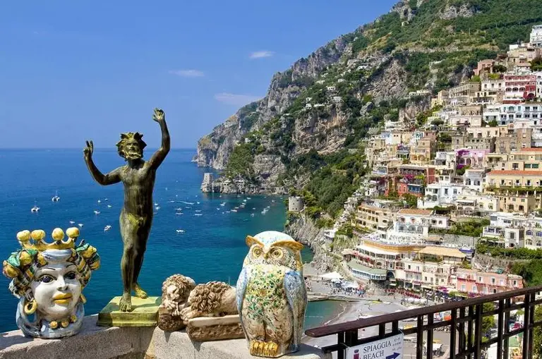 The picture shows the beach of Positano where the picture is taken from the mountainside towards beach in the comparison with Praiano