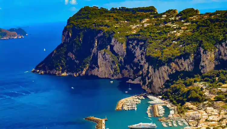 Capri island (Italy) shore is shown in the backdrop of mountain while reviewing it against amalfi coast