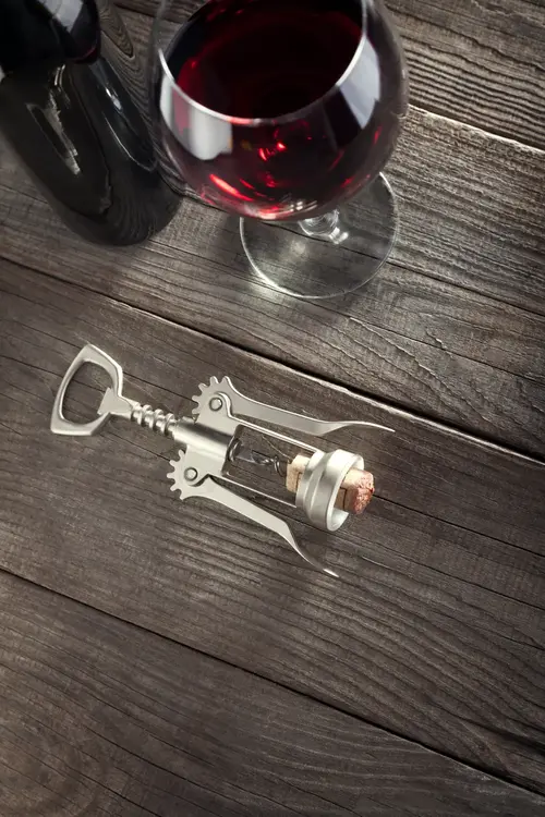 Picture shows a lever corkscrew and a wine bottle