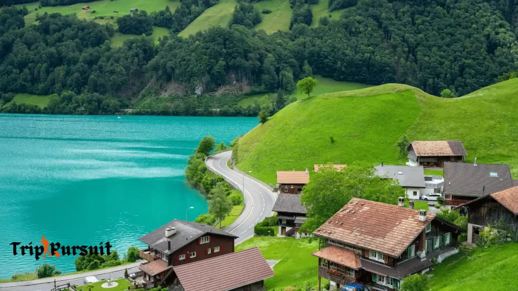 a countryside image of switzerland that shows a lake and houses